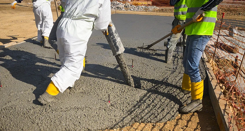 Workers Pouring and Smoothing Wet Concrete for Foundation Repair