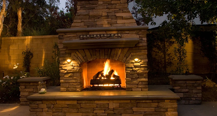 Stone Outdoor Fireplace with Burning Flames and Concrete Construction Elements