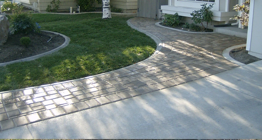 Concrete Driveway and Brick Walkway Leading to a House Entrance